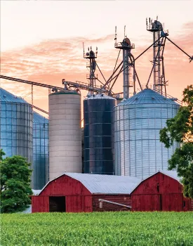 red barn with tall silos behind it