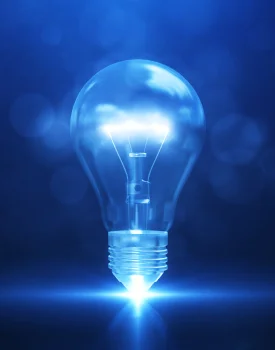 A glowing light bulb, symbolizing innovative HR services, floats with a bright blue glow against a blurred blue background, casting light from its base.