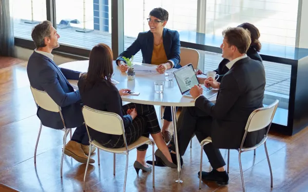 group of people gathered at table wearing business suit