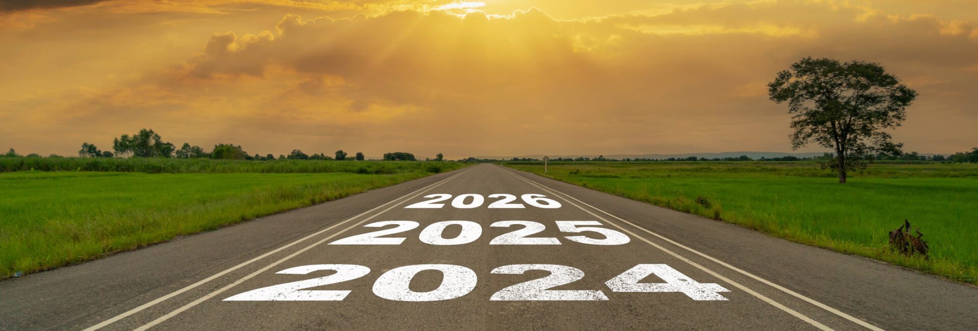 A road stretches into the horizon with the years 2023 to 2026 painted on it, symbolizing future business practices. The sky is bright with clouds and sunlight, offering a hopeful outlook for growth and innovation.