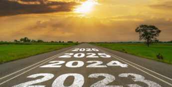 A road stretches into the horizon with the years 2023 to 2026 painted on it, symbolizing future business practices. The sky is bright with clouds and sunlight, offering a hopeful outlook for growth and innovation.