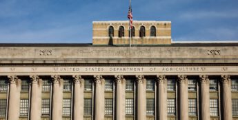 United States Department of Agriculture building with grand columns and an American flag under a clear blue sky, where the latest PARP notice for producers is displayed prominently.