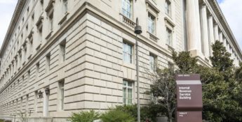 External view of the Internal Revenue Service building with a sign in the foreground, surrounded by shrubs and a lamp post, reflecting its commitment to issues like conservation easements and financial stewardship.
