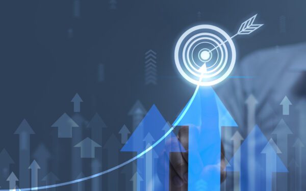 A person touches a virtual target icon, surrounded by upward arrows and a rising graph, symbolizing growth, success, and effective cash flow management on a digital interface.