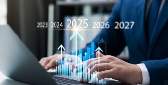 Person using a laptop with a graph overlay, indicating rising trends from 2023 to 2027.
