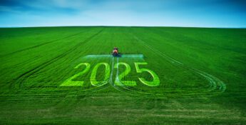 Against a backdrop of a clear blue sky, a red tractor in a green field spells out "2025" in large letters, reminiscent of the precision needed for tax planning in today's complex political climate.
