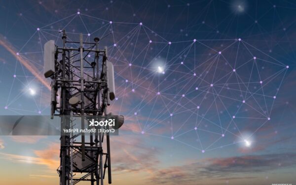 Cellular tower stands against a sunset sky with digital network connections illustrated in the background, symbolizing wireless communication technology.