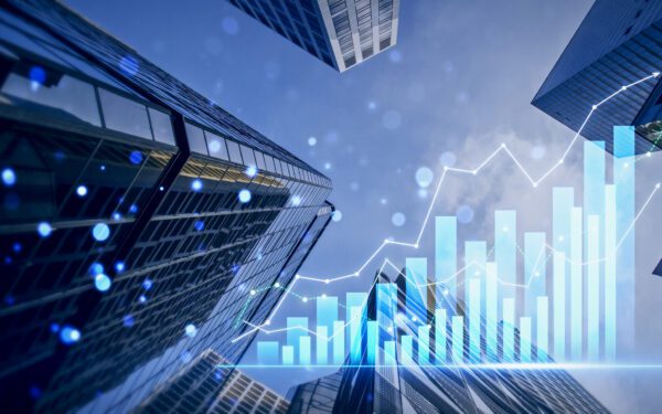Skyscrapers viewed from below with overlaid bar and line graphs representing financial growth and economic data trends.