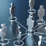 Silver human-shaped figures connected by lines in a network, symbolizing communication, teamwork, or organizational structure on a blue reflective surface.