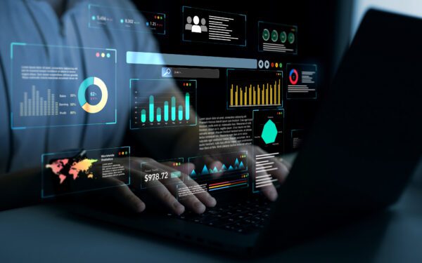 Person using a laptop with digital data dashboards, graphs, and charts projected above the keyboard, representing AI in Sustainability through advanced data analysis and business analytics.