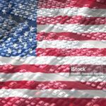 Rows of parked cars in a lot are overlaid with the image of the American flag, symbolizing the US automobile industry and highlighting the importance of Vehicle Loan Interest Reporting.