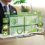 A person in a suit works on a laptop at a desk, using Fieldprint Platform Version 5, with virtual green sustainability and data charts displayed in front of them.