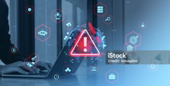 Person typing on a laptop with a large red warning icon and various cybersecurity symbols overlaid, indicating a potential security threat or cyber risk.