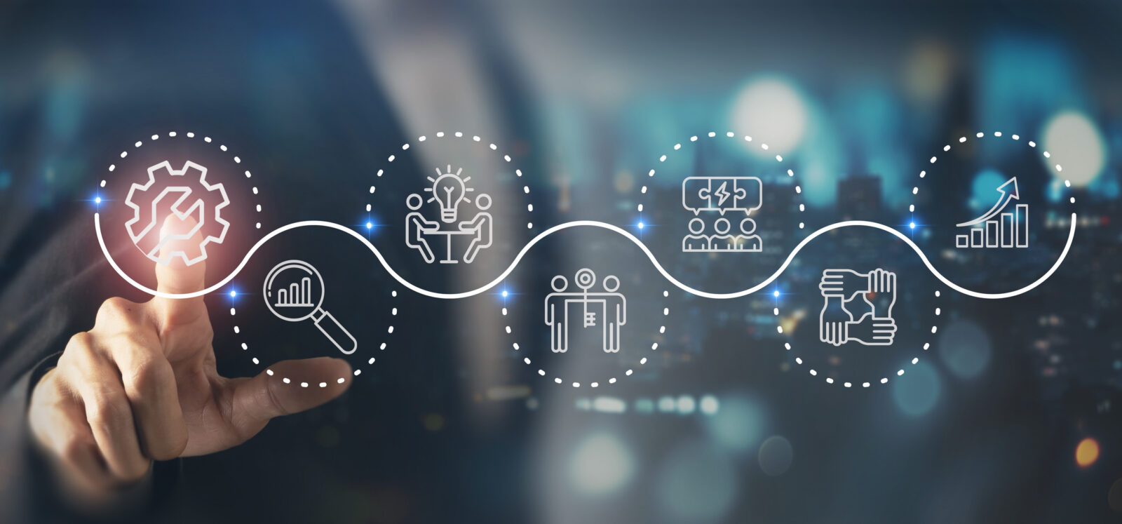 A person points at a digital display showing icons representing workflow steps: process, search, idea, team, analytics, and collaboration, connected by a wavy line.