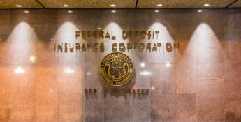 Lobby wall with "Federal Deposit Insurance Corporation" and seal, along with the address "550 17th Street" inscribed in gold lettering, highlights recent updates as the FDIC Signage Deadline Extended to 2027.
