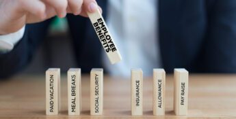 A person arranges wooden blocks labeled with employee benefits such as paid vacation, meal breaks, social security, insurance, allowance, and pay raise—demonstrating the importance of transparency with compensation in the workplace.