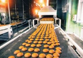 Bakery production line with sweet cookies on conveyor belt in confectionery factory workshop, food production manufacturing