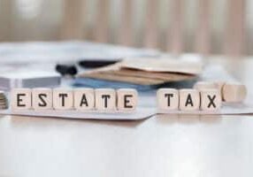 Word ESTATE TAX is composed of wooden letters. Closeup
